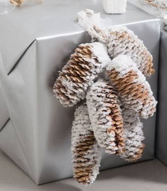 Prenda de natal decorada com pinhas castanhas e brancas